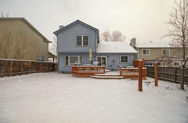 snow covered rear of property featuring a wooden deck