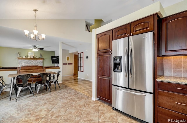 kitchen featuring lofted ceiling, stainless steel fridge with ice dispenser, hanging light fixtures, and ceiling fan with notable chandelier