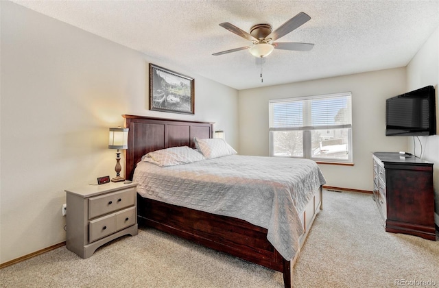 carpeted bedroom featuring ceiling fan and a textured ceiling