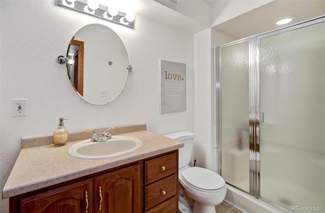 bathroom with vanity, an enclosed shower, and toilet