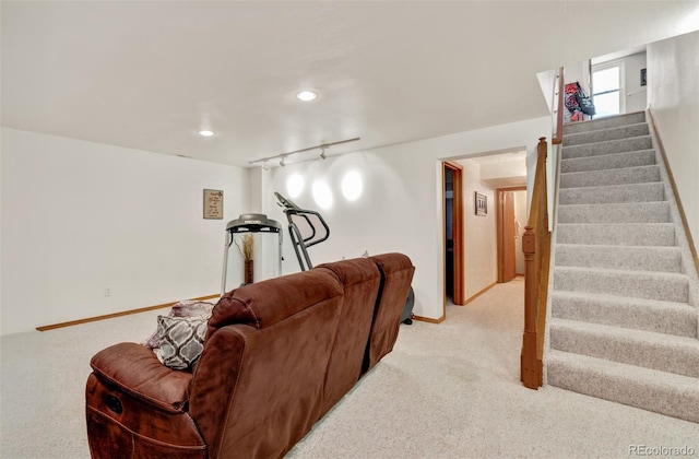 carpeted living room with track lighting