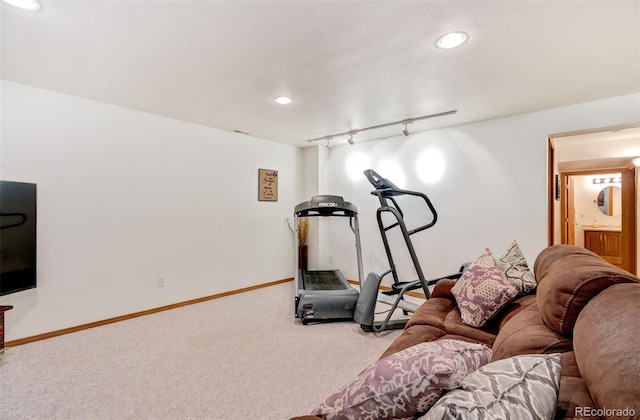 exercise room with rail lighting and light colored carpet