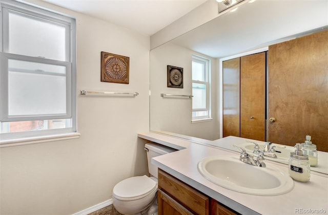 bathroom with vanity, a healthy amount of sunlight, and toilet