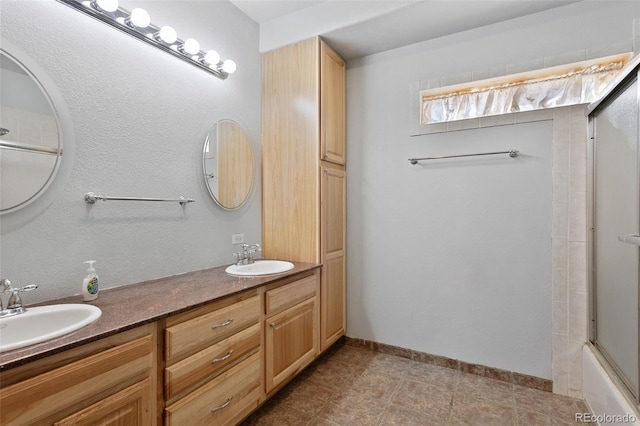 bathroom with vanity and combined bath / shower with glass door