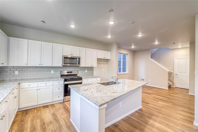 23981 E 40th Ave, Aurora, CO 80019 - kitchen featuring stainless steel appliances, light wood-style flooring, white cabinets, decorative backsplash, and light stone countertops