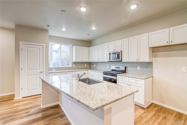 23981 E 40th Ave, Aurora, CO 80019 - kitchen with stainless steel appliances, tasteful backsplash, white cabinetry, light wood-style floors, and recessed lighting