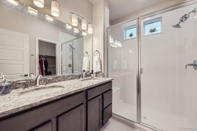 6153 N Ceylon St Unit 2-202, Denver, CO 80249 - bathroom with a stall shower, a spacious closet, and double vanity