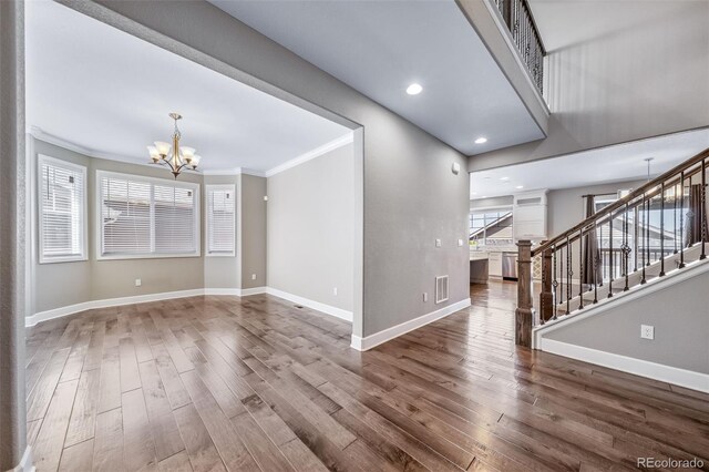 7720 S Queensburg Way, Aurora, CO 80016 - unfurnished living room featuring a chandelier, wood finished floors, crown molding, baseboards, and recessed lighting