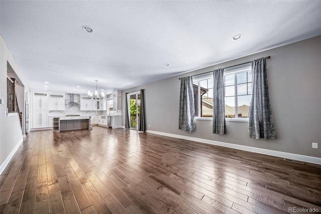 7720 S Queensburg Way, Aurora, CO 80016 - unfurnished living room featuring a chandelier, dark wood finished floors, recessed lighting, and baseboards