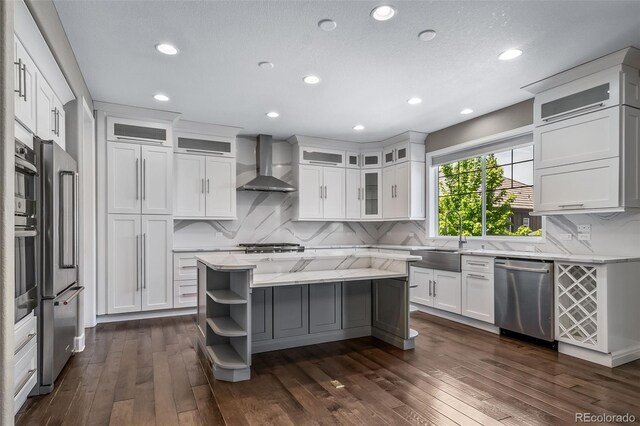 7720 S Queensburg Way, Aurora, CO 80016 - kitchen with appliances with stainless steel finishes, wall chimney exhaust hood, open shelves, white cabinets, and dark wood-type flooring