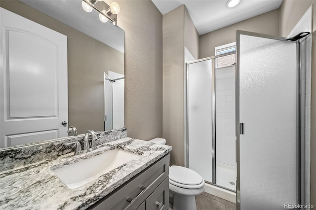 7720 S Queensburg Way, Aurora, CO 80016 - bathroom featuring toilet, vanity, a stall shower, and tile patterned floors