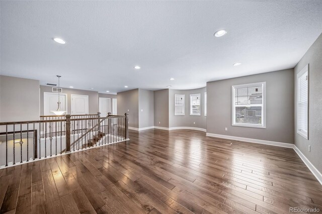 7720 S Queensburg Way, Aurora, CO 80016 - empty room with dark wood finished floors, healthy amount of natural light, baseboards, and recessed lighting