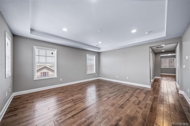 7720 S Queensburg Way, Aurora, CO 80016 - spare room featuring a raised ceiling, dark wood finished floors, healthy amount of natural light, and recessed lighting