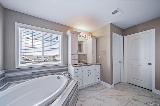 7720 S Queensburg Way, Aurora, CO 80016 - bathroom with vanity, a garden tub, marble look tiles, and baseboards