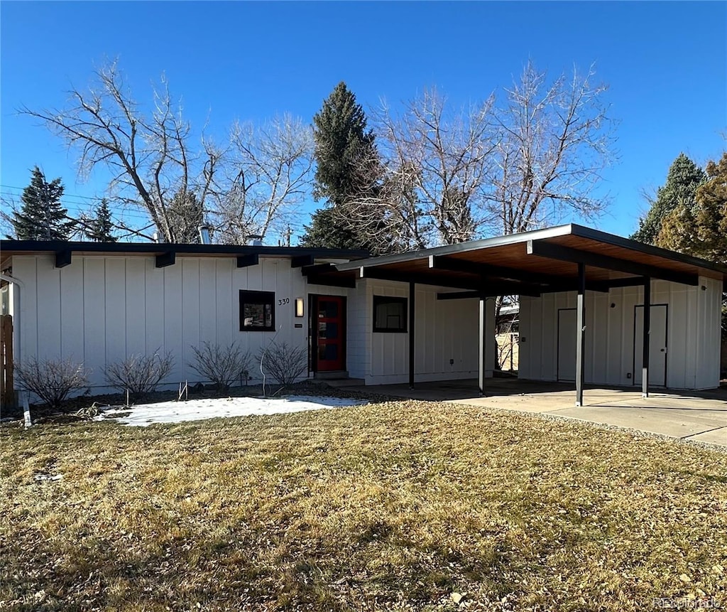 view of front of property featuring a carport, board and batten siding, and a front yard