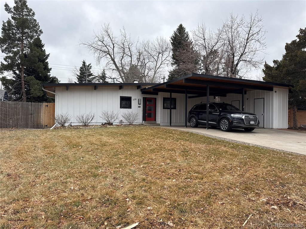 view of front of house with a carport, concrete driveway, fence, and a front lawn