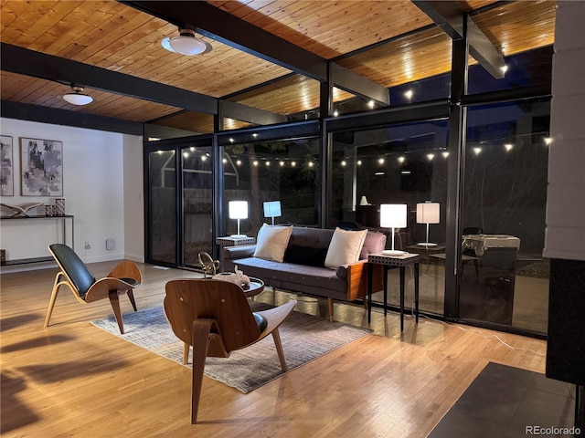 living room featuring beamed ceiling, floor to ceiling windows, wood finished floors, and wooden ceiling