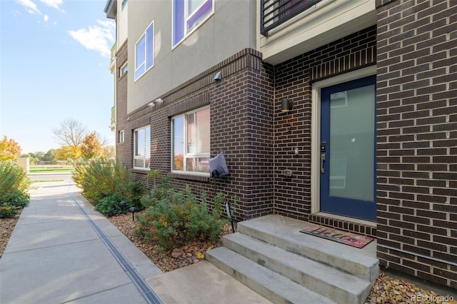 1615 Harlan St Unit 2, Lakewood, CO 80214 - view of exterior entry featuring brick siding and stucco siding
