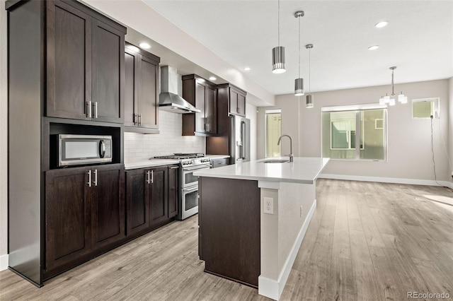 1615 Harlan St Unit 2, Lakewood, CO 80214 - kitchen with wall chimney exhaust hood, high end appliances, a sink, baseboards, and light wood-style flooring