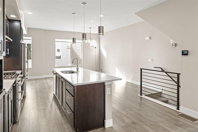 1615 Harlan St Unit 2, Lakewood, CO 80214 - kitchen featuring a sink, range with two ovens, baseboards, a center island with sink, and recessed lighting