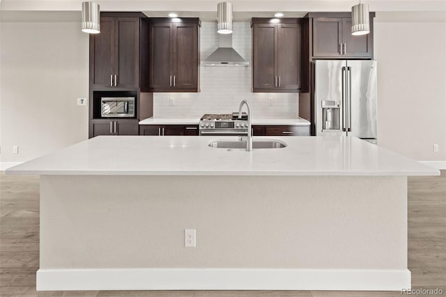 1615 Harlan St Unit 2, Lakewood, CO 80214 - kitchen featuring stainless steel appliances, wall chimney range hood, a sink, and dark brown cabinets