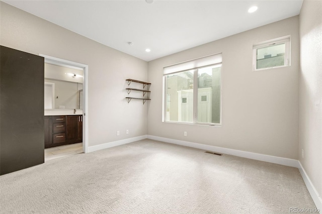 1615 Harlan St Unit 2, Lakewood, CO 80214 - unfurnished bedroom featuring light carpet, baseboards, recessed lighting, and ensuite bathroom