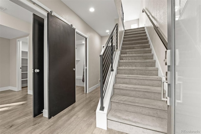 1615 Harlan St Unit 2, Lakewood, CO 80214 - stairs featuring wood finished floors, baseboards, a barn door, and recessed lighting