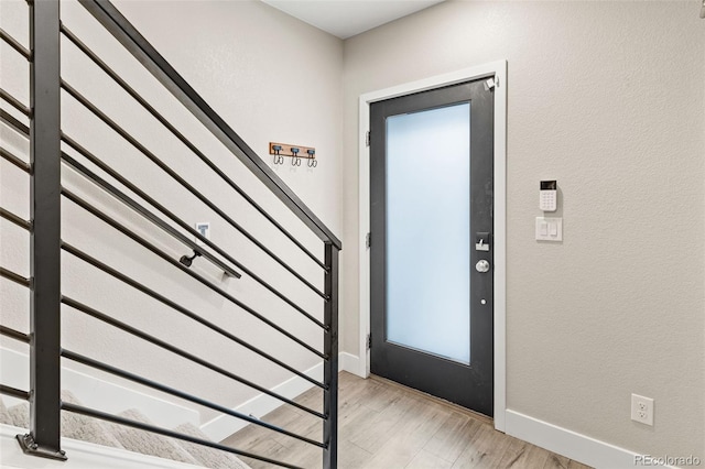1615 Harlan St Unit 2, Lakewood, CO 80214 - entrance foyer featuring light wood-style floors, stairs, baseboards, and a textured wall