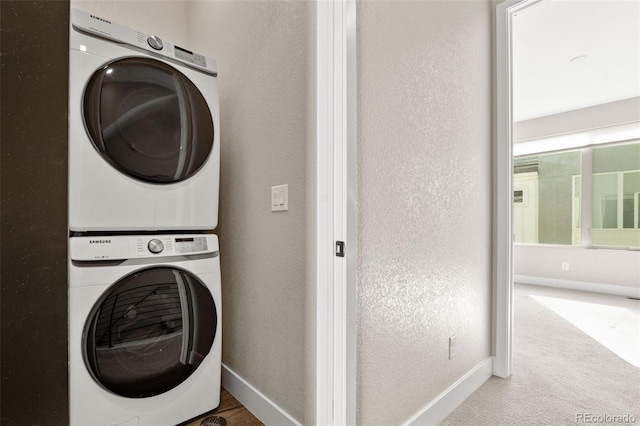 1615 Harlan St Unit 2, Lakewood, CO 80214 - laundry area featuring stacked washer and clothes dryer, baseboards, carpet floors, and a textured wall