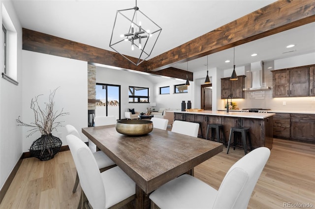 dining area with beam ceiling, a notable chandelier, recessed lighting, and light wood-style floors