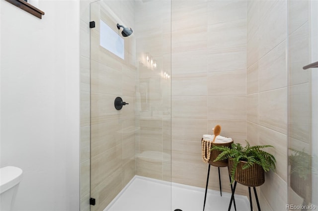 bathroom with a shower stall and toilet