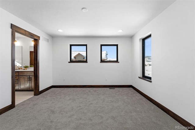 unfurnished room with visible vents, baseboards, and carpet