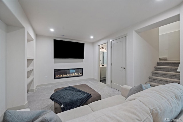 1100 Blue Bell Rd, Berthoud, CO 80513 - carpeted living area featuring a glass covered fireplace, recessed lighting, baseboards, and stairway