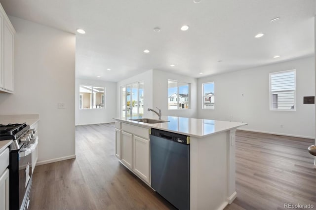 kitchen featuring white cabinets, appliances with stainless steel finishes, plenty of natural light, and a kitchen island with sink