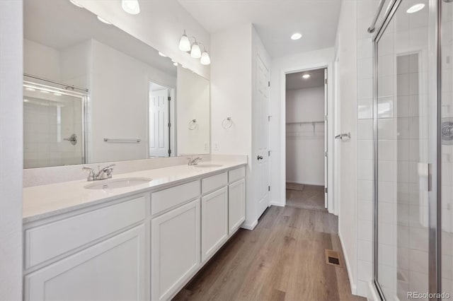 bathroom with vanity, an enclosed shower, and wood-type flooring