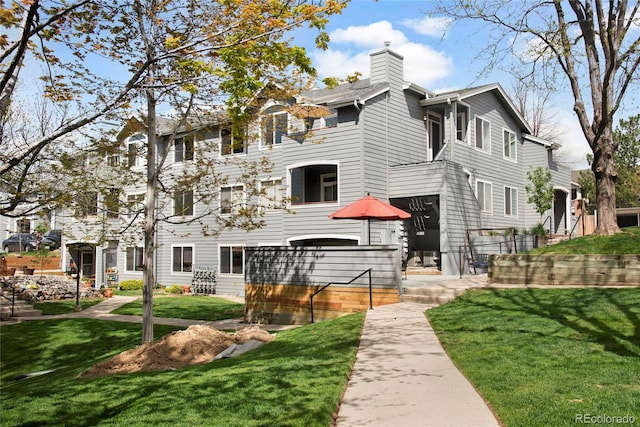 8500 E Jefferson Ave Unit 11C, Denver, CO 80237 - back of house with a chimney and a yard