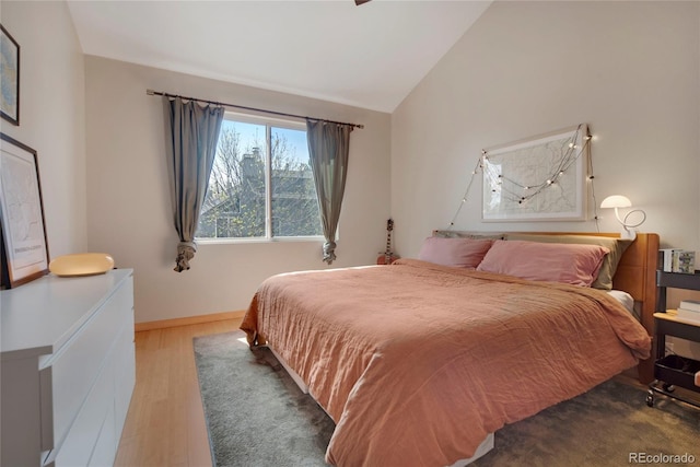 8500 E Jefferson Ave Unit 11C, Denver, CO 80237 - bedroom with vaulted ceiling, wood finished floors, and baseboards