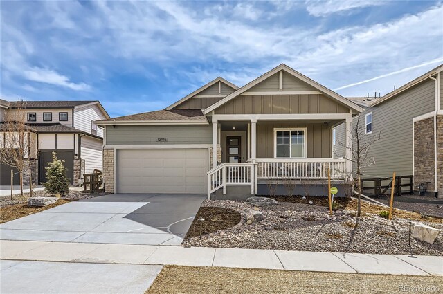 view of front facade featuring an attached garage, driveway, a porch, and board and batten siding