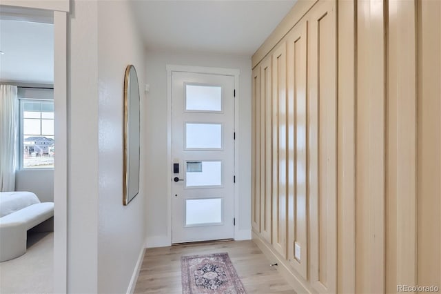 doorway featuring light wood-type flooring and baseboards