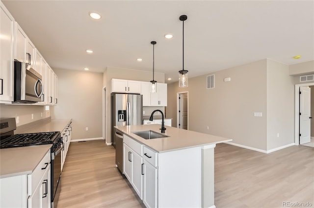 4102 Estrella St, Brighton, CO 80601 - kitchen featuring stainless steel appliances, light wood-type flooring, light countertops, recessed lighting, and an island with sink