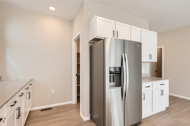 4102 Estrella St, Brighton, CO 80601 - kitchen featuring stainless steel fridge, light wood-type flooring, white cabinets, light countertops, and recessed lighting
