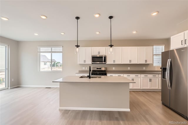 4102 Estrella St, Brighton, CO 80601 - kitchen featuring stainless steel appliances, light wood finished floors, healthy amount of natural light, hanging light fixtures, and recessed lighting