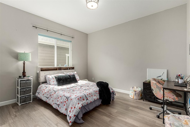 bedroom with baseboards and wood finished floors