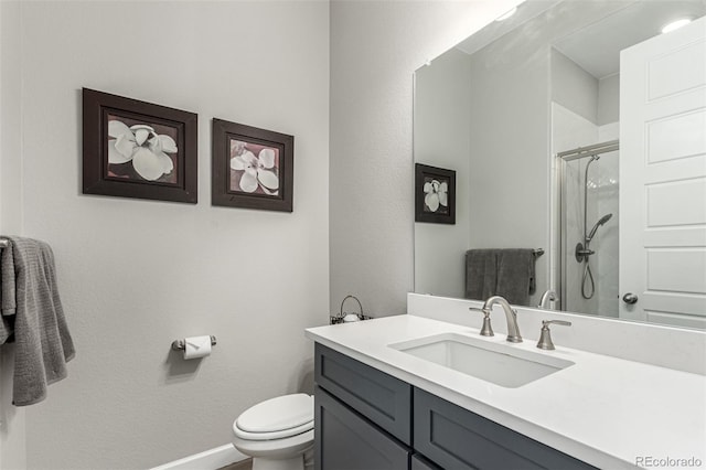 full bathroom with toilet, baseboards, vanity, and a stall shower