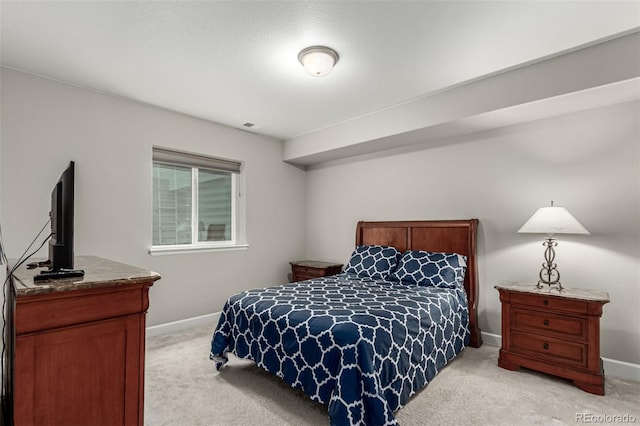 bedroom with baseboards and light carpet