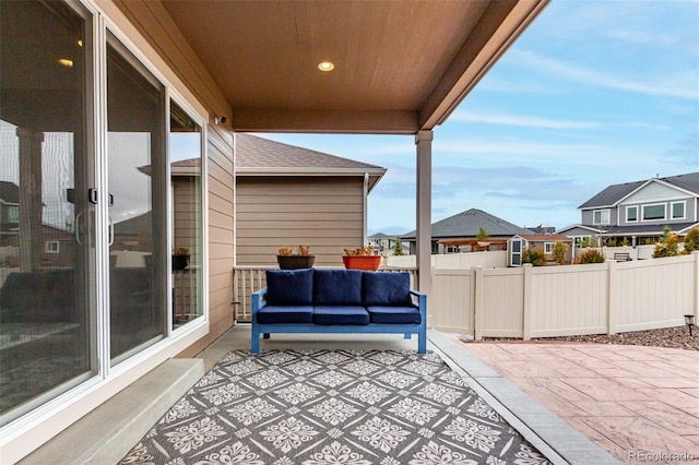 view of patio with outdoor lounge area, a residential view, and fence