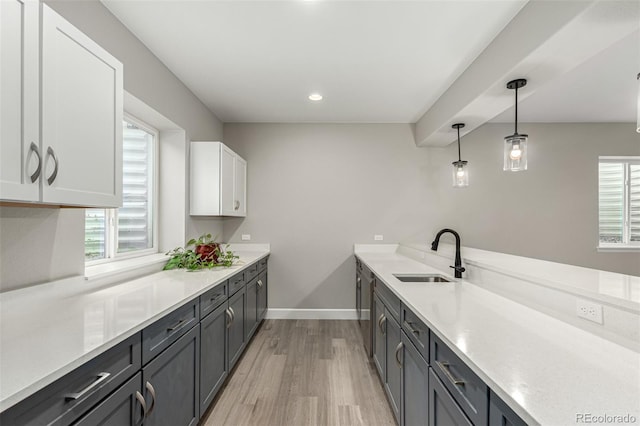 5839 Hay Market Trl, Parker, CO 80134 - kitchen with a sink, light wood finished floors, dishwasher, white cabinets, and light countertops