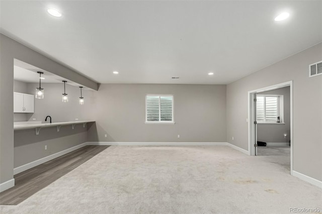 5839 Hay Market Trl, Parker, CO 80134 - unfurnished living room featuring baseboards, recessed lighting, light colored carpet, and a sink