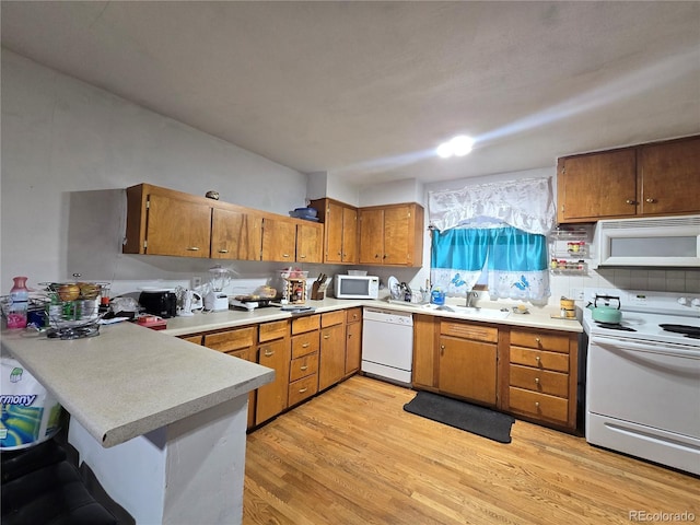 7371 Granada Rd, Denver, CO 80221 - kitchen featuring white appliances, light countertops, light wood-style floors, a peninsula, and brown cabinets