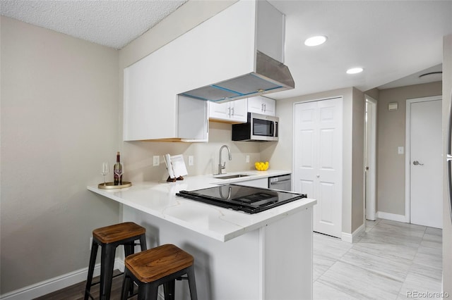 2856 S Kenton Ct, Aurora, CO 80014 - kitchen featuring stainless steel appliances, a kitchen bar, a peninsula, white cabinetry, and recessed lighting